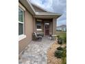 Inviting front porch with stone accents and rocking chairs at 10201 Sw 96Th Loop, Ocala, FL 34481