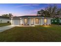 Single-story house with a white exterior, a garage, and a neatly landscaped lawn at 2245 Sw 146 Avenue Rd, Ocala, FL 34481