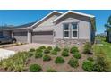 Two-car garage with stone accents and landscaping at 5319 Nw 34Th St, Ocala, FL 34482