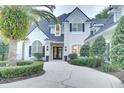 Two-story house with a gray roof, landscaped yard, and circular driveway at 7070 Se 14Th Ct, Ocala, FL 34480