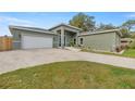 Modern home with light green exterior, attached garage, and landscaping at 10250 Sw 82Nd Ct, Ocala, FL 34481