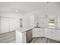 Modern white kitchen with granite island and stainless steel dishwasher at 2688 Sw Wave Ln, Dunnellon, FL 34431