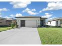 Front view of a house with a two-car garage and a landscaped lawn at 6119 Sw 93Rd Cir, Ocala, FL 34481