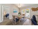 Dining room with a rustic wooden table and blue chairs, offering access to a backyard at 13087 Sw 86Th Ct, Ocala, FL 34473