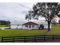 White home with brown accents, porch, and large yard at 3550 Sw 210Th Ave, Dunnellon, FL 34431