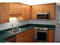 Kitchen with light wood cabinets, stainless steel appliances, and a green countertop at 3706 Ne 16Th Pl, Ocala, FL 34470