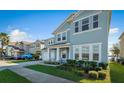 Two-story house with light blue exterior, white garage door, and landscaped front yard at 455 Blue Cypress Dr, Groveland, FL 34736