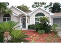 House exterior featuring a light beige facade and lush landscaping at 8473 Sw 108Th Place Rd, Ocala, FL 34481