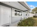 Front entrance with white door, gray siding, and white shutters at 10930 Sw 83Rd Ct, Ocala, FL 34481