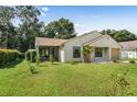 House with a screened porch, mature trees, and a spacious lawn at 21174 Sw Peach Blossom St, Dunnellon, FL 34431
