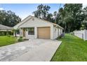 Single-story house with a beige exterior, attached garage, and a concrete driveway at 21174 Sw Peach Blossom St, Dunnellon, FL 34431