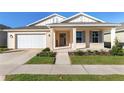 Tan house with gray shutters, white garage door, and a covered front porch at 6200 Sw 72Nd Ter, Ocala, FL 34474