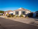 Tan single-story house with a two-car garage and landscaped front yard at 2379 Chestnut Ter, The Villages, FL 32162