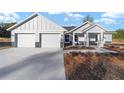 Two-story house with gray siding, stone accents, and a two-car garage at 4422 Sw Begonia Ct, Dunnellon, FL 34431