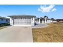 House exterior showcasing a two-car garage and well-maintained lawn at 5971 Sw 99Th Pl, Ocala, FL 34476