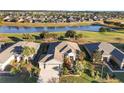 An aerial view showcasing a house, lush landscaping, and a tranquil lake with a golf course visible in the distance at 6671 Sw 97Th Terrace Rd, Ocala, FL 34481