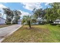 Home's exterior showcasing a palm tree and spacious lawn at 10816 Sw 83Rd Ave, Ocala, FL 34481