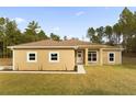 Front view of a single-story house with a light brown stucco exterior and a neatly manicured lawn at 12205 Sw 71St Lane Rd, Ocala, FL 34481