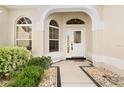 Inviting entryway with white door, arched windows, and stone path at 17325 Se 73Rd Park Glen Ct, The Villages, FL 32162