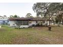 Rear view of house showing screened porch and AC unit at 17411 Se 18Th St, Silver Springs, FL 34488