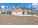 Tan house with three-car garage and a fire hydrant at 4313 Sw 106Th Pl, Ocala, FL 34476