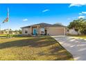 One-story home with teal door, driveway and American flag at 6560 Sw 129Th St, Ocala, FL 34473