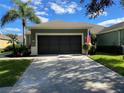 House exterior featuring a two-car garage and well-manicured lawn at 9586 70Th Sw Loop, Ocala, FL 34481