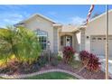 Home's front entrance with landscaping and a three-car garage at 12157 Se 175Th Loop, Summerfield, FL 34491