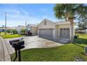 House exterior showcasing a three-car garage and manicured lawn at 12157 Se 175Th Loop, Summerfield, FL 34491