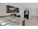 Modern kitchen with granite countertops and dark brown cabinets at 15055 Sw 39Th Cir, Ocala, FL 34473