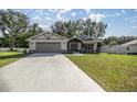 New house with gray siding, stone accents, and a two-car garage at 6610 Sw 109Th Ln, Ocala, FL 34476