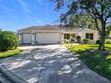 Two-car garage, driveway and nicely landscaped front yard at 725 Beldon Ct, The Villages, FL 32162