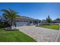 Home's exterior showcasing landscaping, driveway, and a two-car garage at 9307 Sw 104Th Ter, Ocala, FL 34481