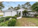 White house with gray accents, landscaping, and a two-car garage at 11661 Sw 70Th Ct, Ocala, FL 34476