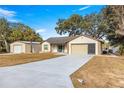 Single-story home's exterior showcases a two-car garage and a stone facade at 17757 Se 28Th Ln, Silver Springs, FL 34488