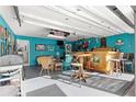 Brightly colored garage converted into a bar area with seating and a home gym at 17757 Se 28Th Ln, Silver Springs, FL 34488