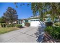 Two-car garage with a wide driveway and neatly trimmed landscaping at 7947 Sw 83Rd Pl, Ocala, FL 34476