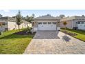 New construction home with two-car garage and paver driveway at 10338 Sw 99Th Ln, Ocala, FL 34481