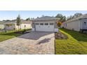 New construction home with two-car garage and paver driveway at 10338 Sw 99Th Ln, Ocala, FL 34481