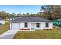 Newly built home featuring a gray roof, white exterior, and landscaping at 1877 Sw 150 Ct, Ocala, FL 34481