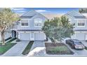 Three-unit townhome building with light blue exterior, two-car garages, and landscaping at 4500 Sw 52Nd Cir # 104, Ocala, FL 34474