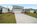 Two-story house with gray siding, stone accents, and a large driveway at 5886 Sw 78Th Avenue Rd, Ocala, FL 34474
