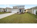 Two-story house with gray siding, stone accents, and a two-car garage at 5886 Sw 78Th Avenue Rd, Ocala, FL 34474