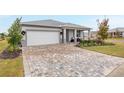 Landscaped front yard with brick pavers, and a two-car garage at 8916 Sw 78Th Street Rd, Ocala, FL 34481
