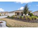 Landscaped yard with a two-car garage at 9725 Sw 108Th Terrace Rd, Ocala, FL 34481
