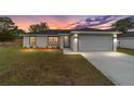 Newly built home with a gray garage door and landscaping at 10161 Sw 137Th Ct, Dunnellon, FL 34432