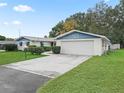 Exterior view of the home showcasing the attached garage and spacious driveway at 39 Emerald Dr, Ocala, FL 34472