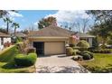 One-story home with landscaped yard, paver driveway, and screened-in garage at 7305 Sw 99Th Cir, Ocala, FL 34481