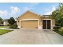 Two-car garage with tan exterior and screen door at 9948 Sw 69Th Ln, Ocala, FL 34481