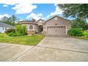 House exterior featuring a two-car garage and well-manicured lawn at 3803 Se 6Th Ave, Ocala, FL 34480